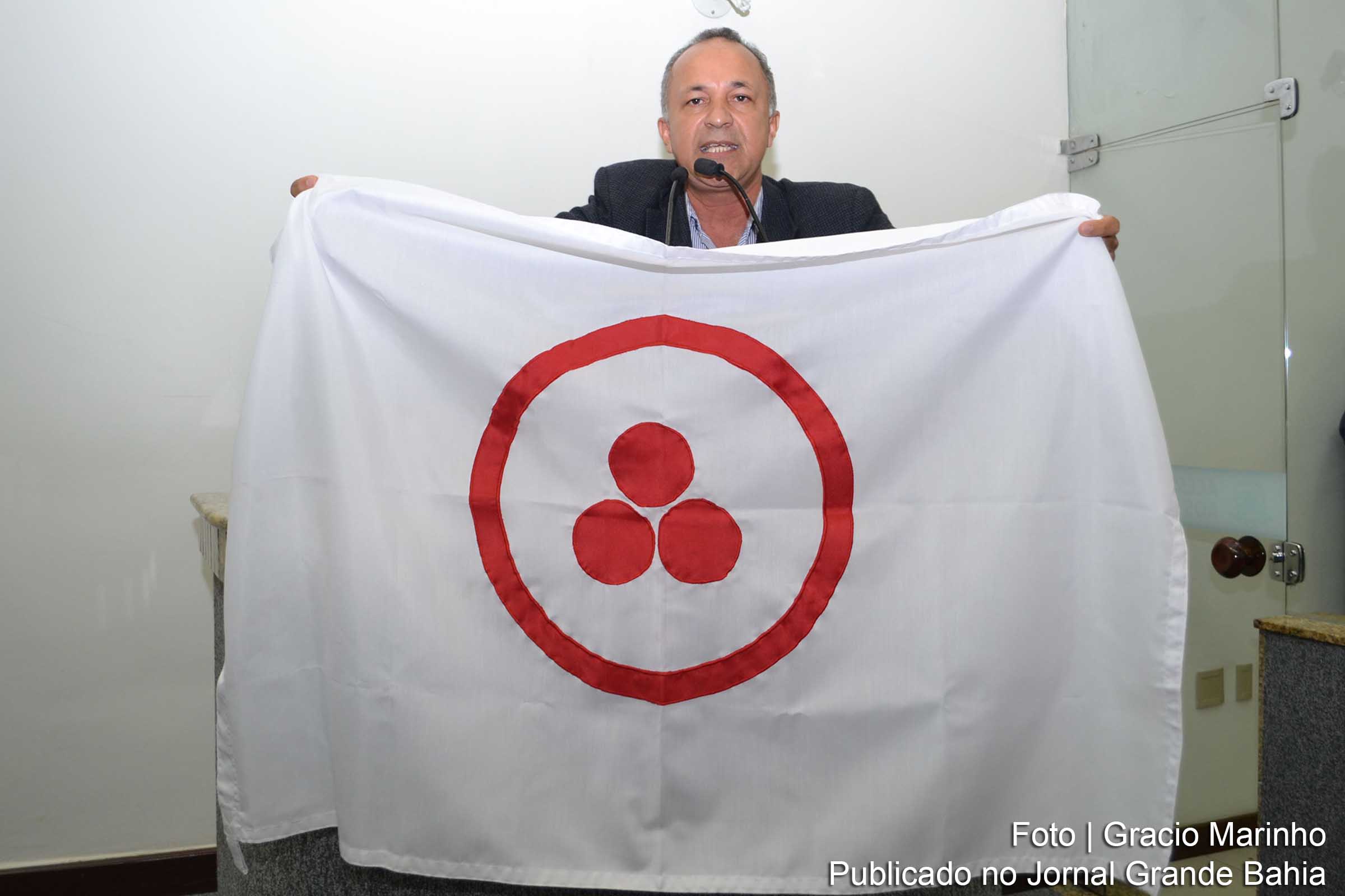 Paulo Cesar dos Santos apresenta a bandeira da Paz e Cultura.