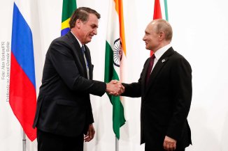 Presidentes Jair Bolsonaro e Vladimir Putin trocam cumprimento durante encontro ocorrido em 27 de junho de 2019.